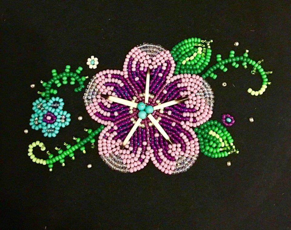 Traditional beading in the shape of a flower and vines.