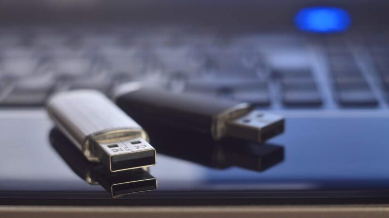 Two USB sticks sitting on a laptop trackpad.