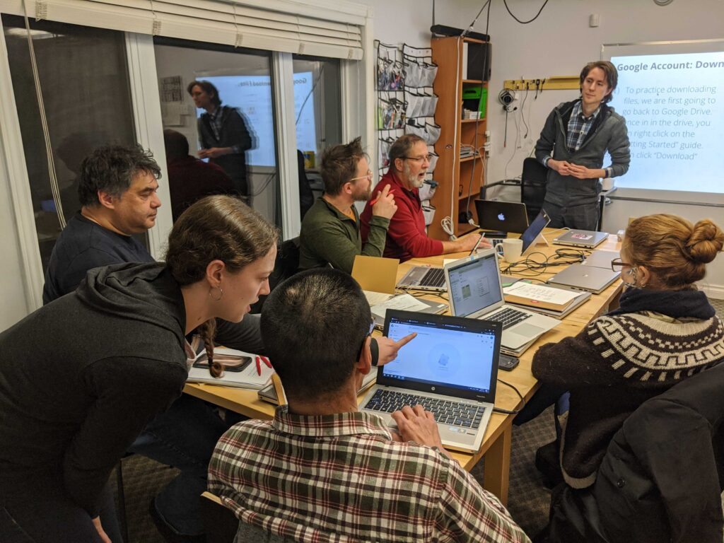 Adult workshop adults with laptops sitting around a table
