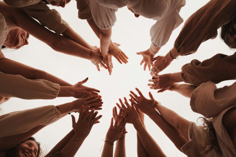 group of people huddled together hands in the middle