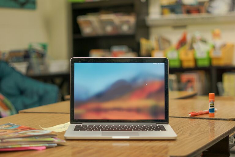 A Macbook computer is sitting on a table. The start screen is open.