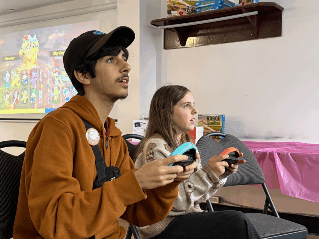 Bathurst Makerspace staff playing Nintendo Switch with youth program participant, Lennon