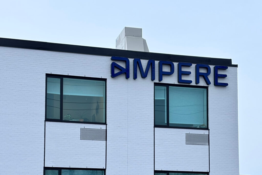 The top of the Ampere building, showing the dark blue ampere sign.