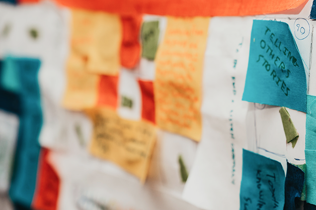 A close up of a quilt being assembled with hand written notes. 