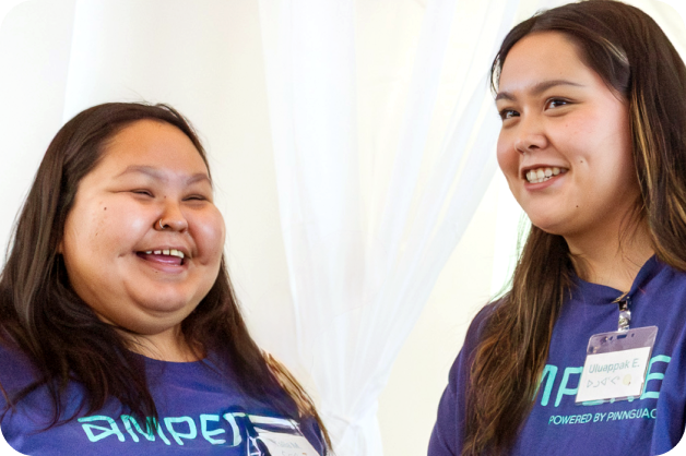 develop-digital-ai-skills-benefits-4-indigenous woman presenting Two Ampere staff are standing side by side, slightly facing each other and are smiling.
