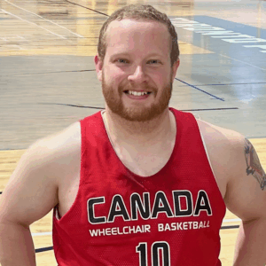 Eric Voss in a basketball jersey. He is smiling at the camera.
