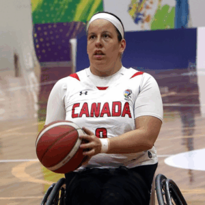 Tamara Steeves in her basketball uniform. She is holding a basketball and looking upwards.