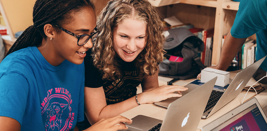 two-students-learning-on-laptops Two students are working on a laptop. They are both smiling.