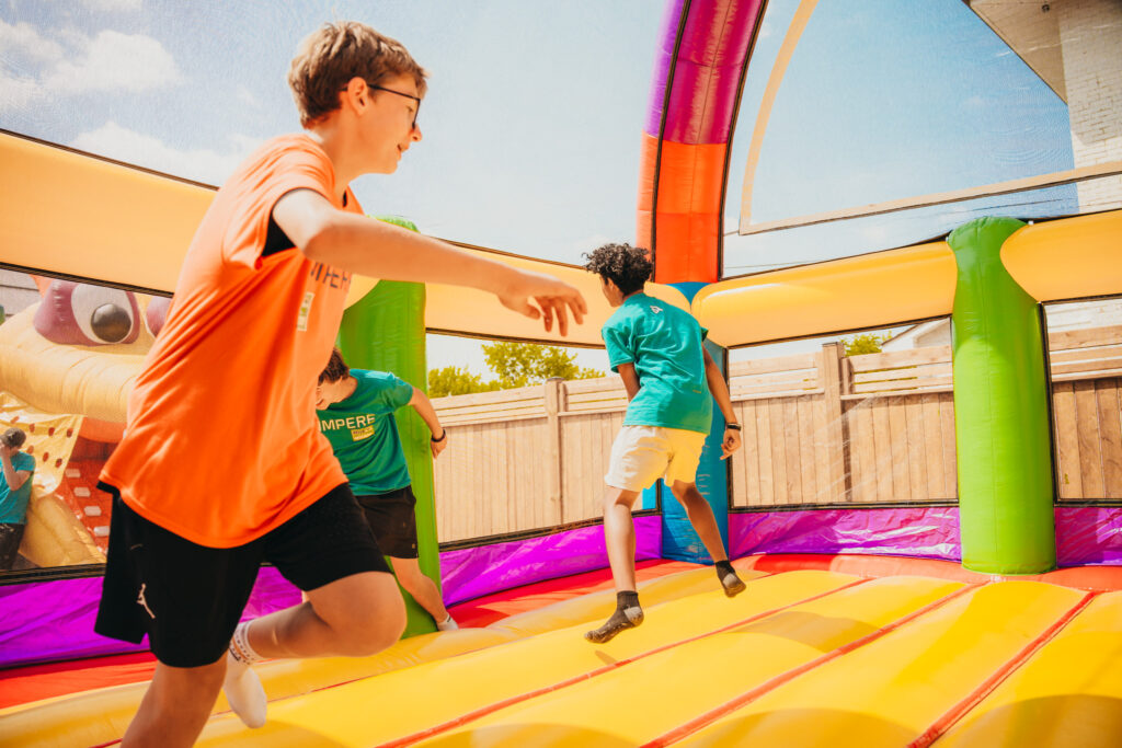 An Ampere volunteer actively jumping on a bouncy castle at STEM Fest 2025.