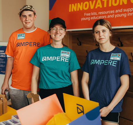 Makerspace staff standing in front of the Innovation club sign.