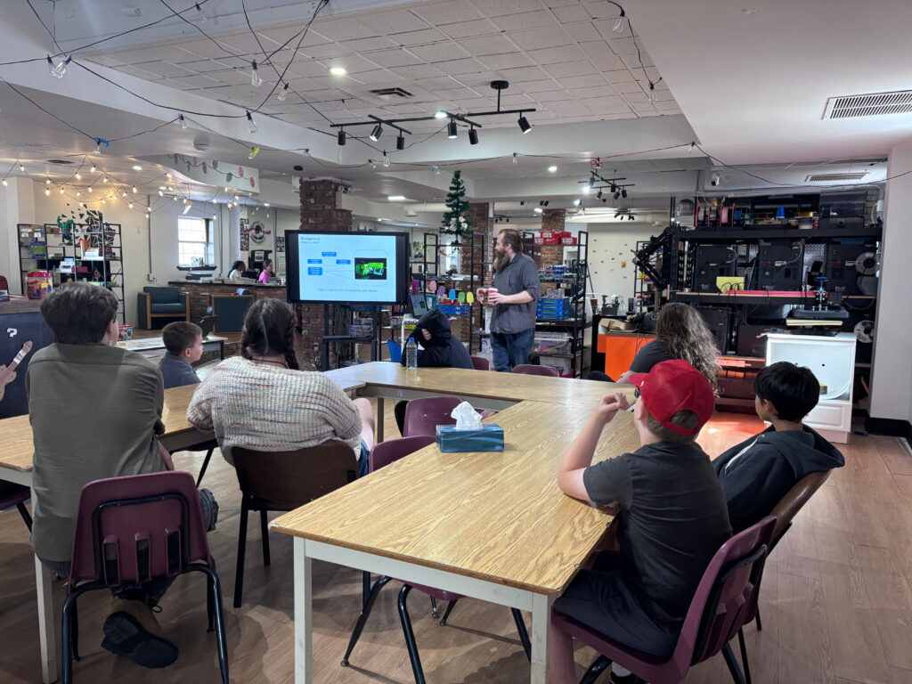 An Ampere Bathurst community partner leads a workshop in the Bathurst Makerspace & Skills Hub. Participants sit at tables.