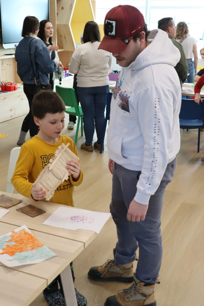 A parent and child are at a table in the Kawartha Lakes Makerspace and Skills Hub interacting with STEAM activities.