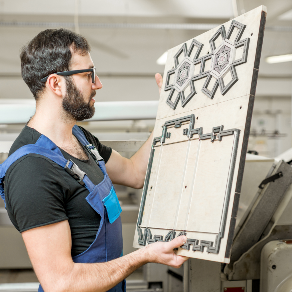 A trades teacher holding a prototype up in front of himself. He is looking at the prototype.